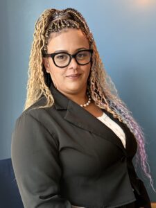 Chantelle, a Parent Champion, wearing glasses and a suit jacket.